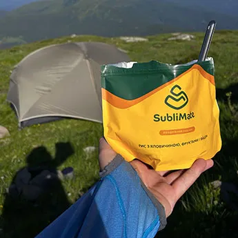 Їжа для походу SubliMate Страва Рис з куркою, фруктами і яйцем SubliMate на тлі туристичного намету