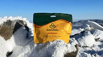 Їжа з собою SubliMate для зимових подорожей Паковання скремблу з копченою куркою SubliMate на засніженій гірській вершині