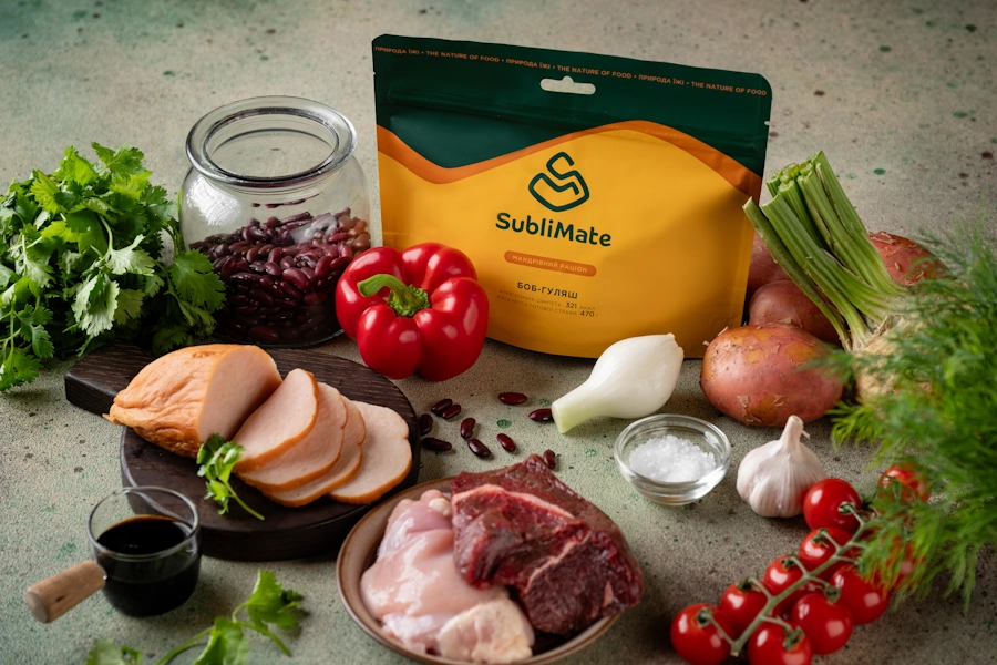 Повний набір продуктів для приготування густого м’ясного гуляшу — свіже м’ясо, овочі, перець, квасоля, зелень і готова упаковка страви