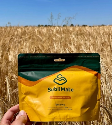 Жовта упаковка Бограчу SubliMate на фоні української ниви та синього неба.