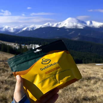 На фото в руці — сублімована їжа SubliMate з креветками у вершковому соусі, яку зручно взяти в гори, подорож чи авто.