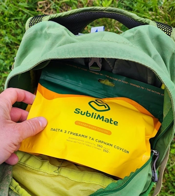Пакет пасти з грибами та сирним соусом Sublimate лежить у відкритому рюкзаку перед виходом у похід