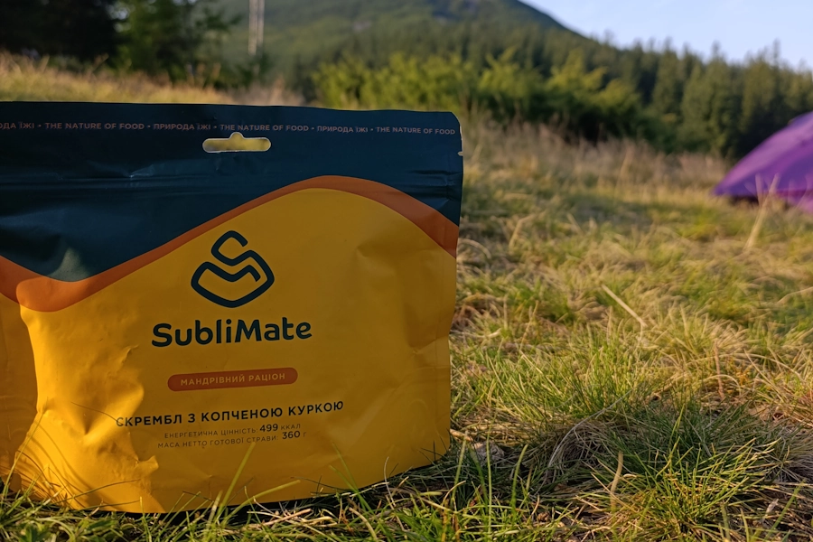 Гарячий поживний сніданок SubliMate у туристичному наметі з краєвидом на схід сонця — ідеальне харчування для мандрівника.